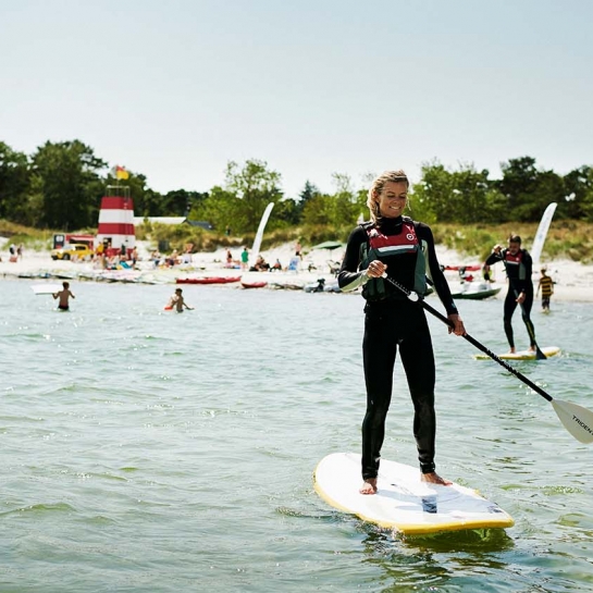 Kvinde står på stand up paddleboard